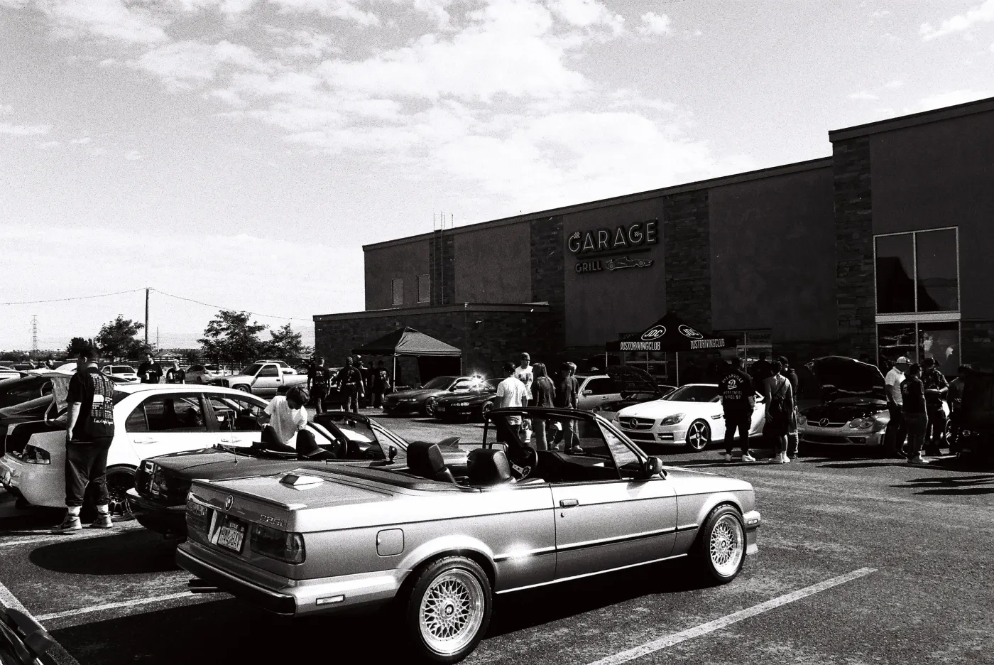 Black and white photo of a BMW E30 convertible at a JDC meet