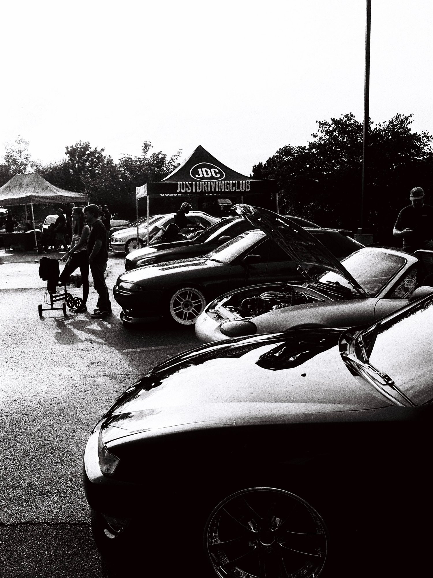 Black and white film photo of the JDC tent and lineup in the rain